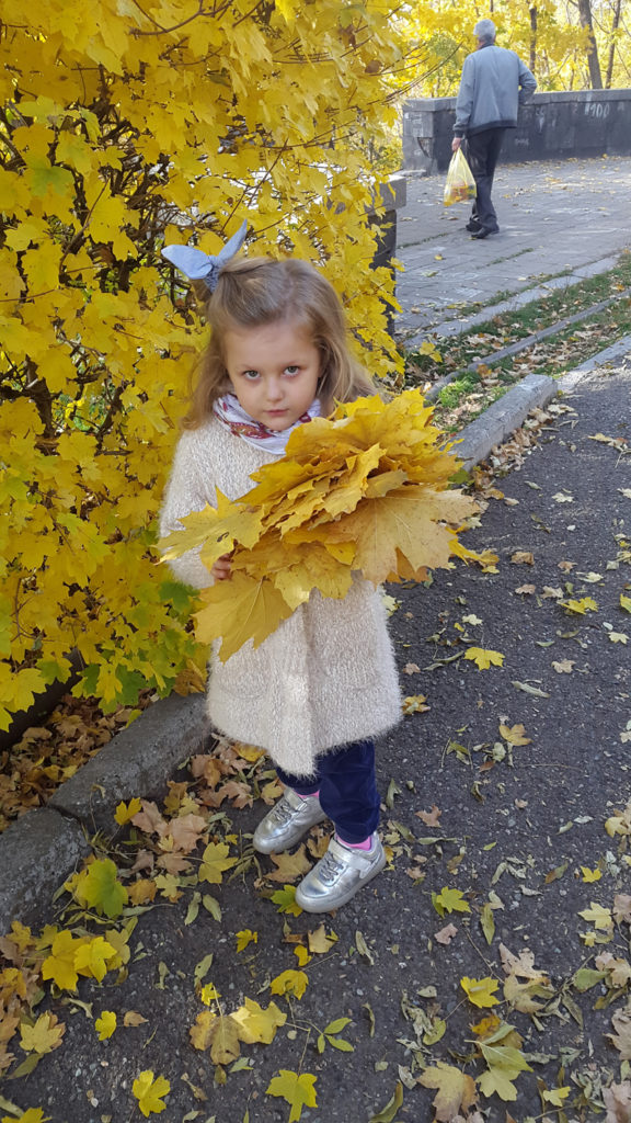 A Yerevan girl collects handfuls of fall foliage. Photo credit: Anya von Bremzen