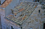 A cat prowls on an older Dubrovnik tiled roof, contrasted with a newer one on the left that likely was repaired from war damage. Photo credit: Laneya McCullough