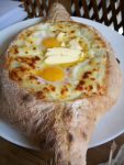Ajarian khachapuri - a bread with cheese, butter, and eggs.