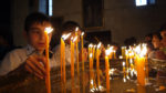Young believers light candles in Armenia's Echmiadzin Cathedral. Photo credit: Martin Klimenta