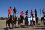 Strike a pose! MIR travelers pause for a photo op with the skilled horseback riders of Kyrgyzstan. Photo credit: Russ Cmolik & Ellen Cmolik