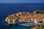 Dubrovnik and the city walls against the azure Adriatic Sea.