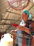 A woman offers up servings of her batch of kymyz. Photo credit: Michel Behar