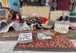 Kyrgyz women busy with making shyrdak and ala-kiyiz.