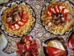 Plov, served with stuffed peppers and pomegranates in Kokand, Uzbekistan. Photo credit: Abdu Samadov