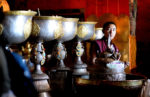 Tibetan monk with ritual cups. Photo credit: Phil Kidd
