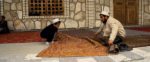 Father and son roll up rugs in Tajikistan. Photo credit: Michel Behar
