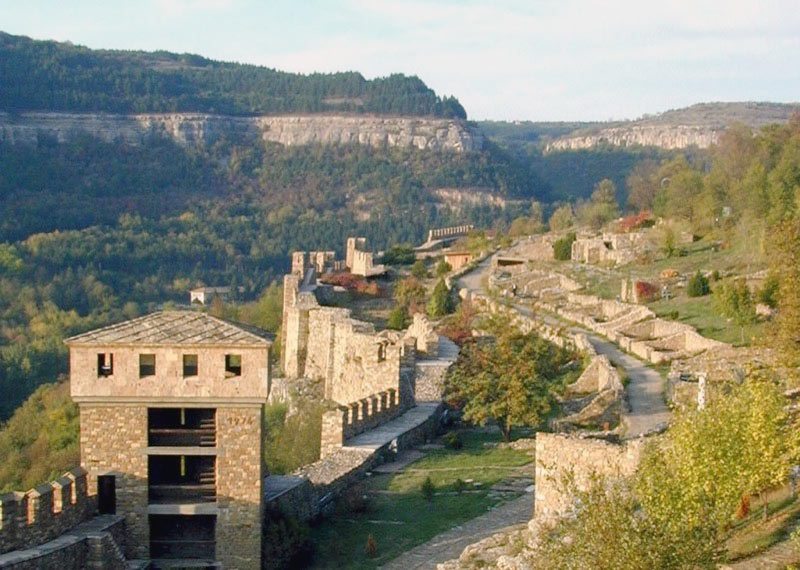 Stone foundations of royal homes guarded by a reconstructed watchtower in the fortress walls. Photo credit: Alexander Tour